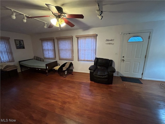 living area with ceiling fan, dark hardwood / wood-style flooring, and rail lighting