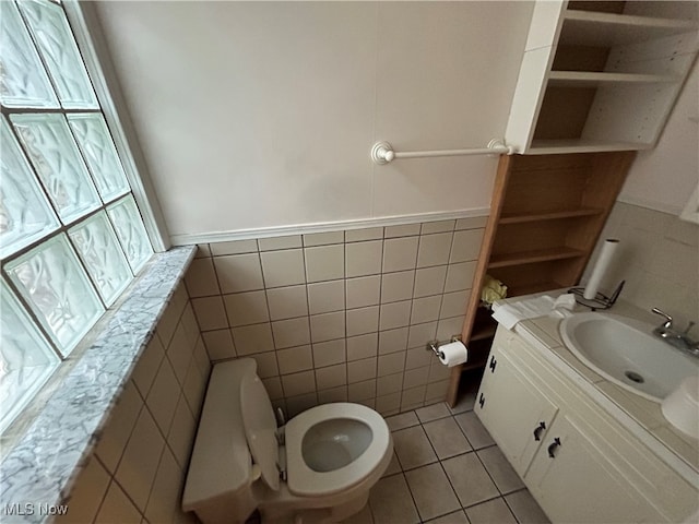 bathroom with tile patterned floors, vanity, toilet, and tile walls