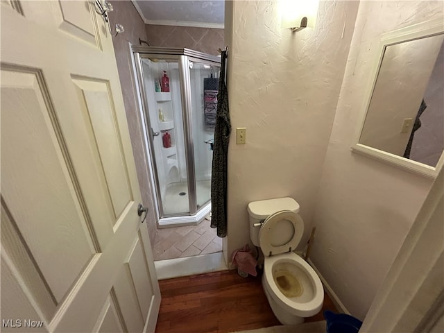 bathroom featuring a shower with door, toilet, wood-type flooring, and crown molding