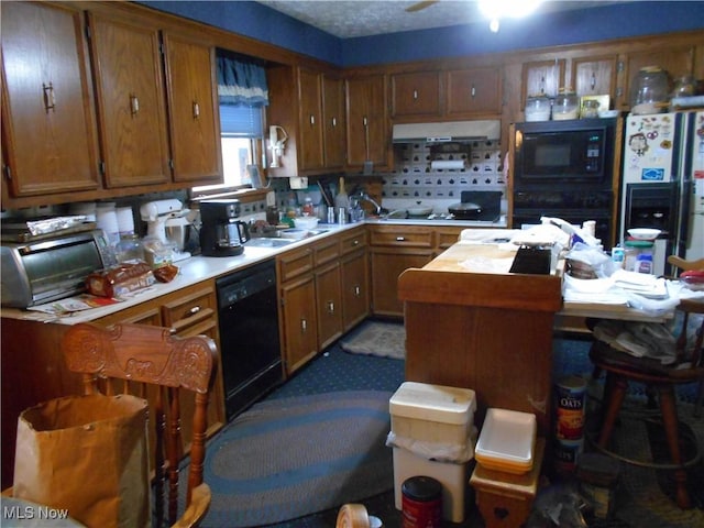 kitchen with sink, black appliances, and extractor fan