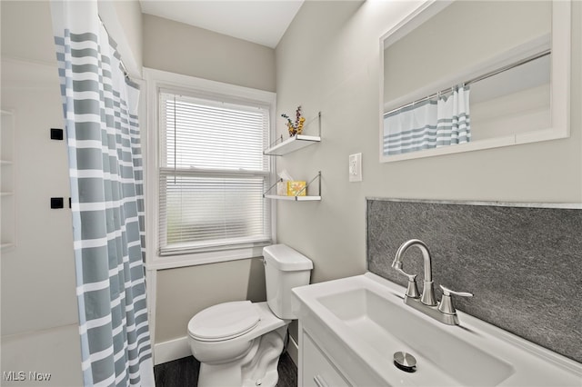 bathroom with decorative backsplash, vanity, and toilet