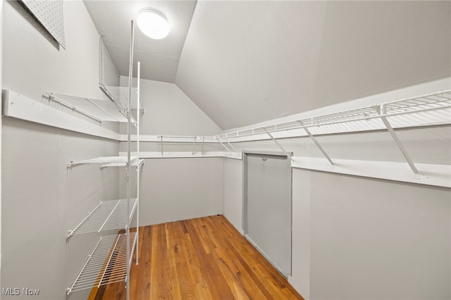 spacious closet featuring hardwood / wood-style floors and lofted ceiling