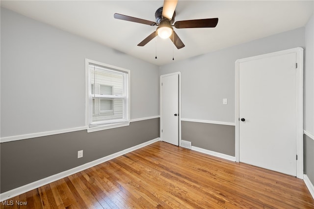 unfurnished bedroom with ceiling fan and hardwood / wood-style flooring