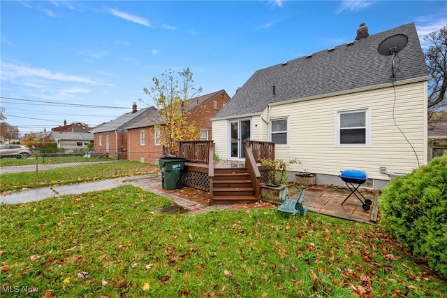 rear view of property featuring a lawn and a wooden deck