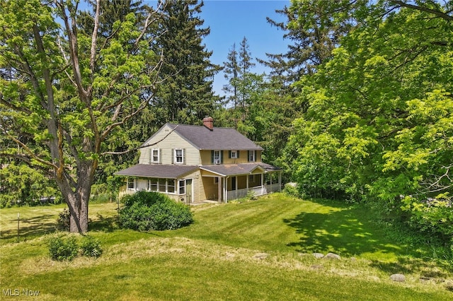 view of front facade with a front lawn and a sunroom