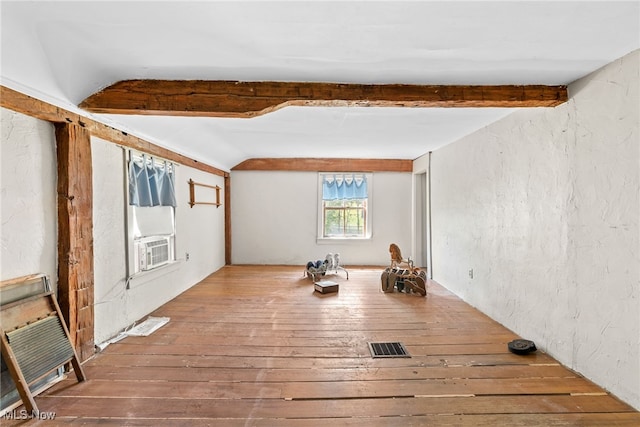 interior space with beamed ceiling, wood-type flooring, and cooling unit