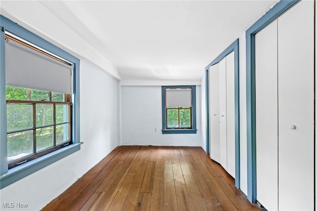 unfurnished bedroom featuring two closets and dark hardwood / wood-style floors