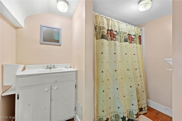 bathroom with hardwood / wood-style floors, vanity, and vaulted ceiling