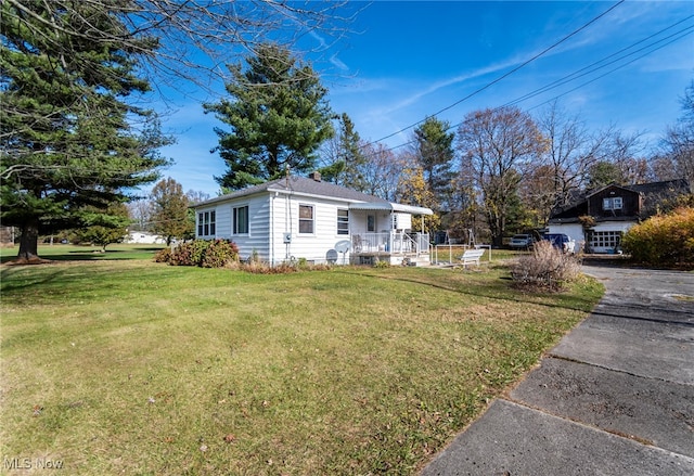 view of side of home with a lawn and covered porch