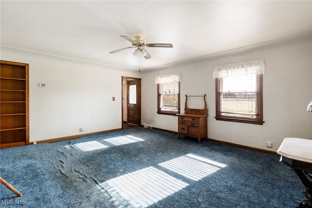 interior space with ceiling fan and dark carpet