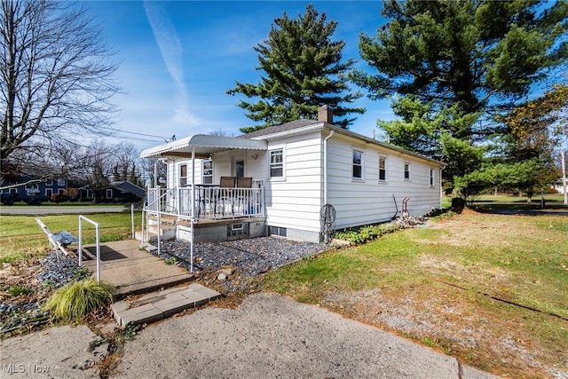 view of front of property featuring covered porch and a front yard