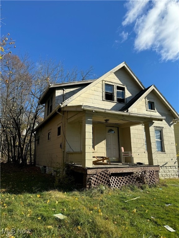 view of front of house with covered porch and a front lawn