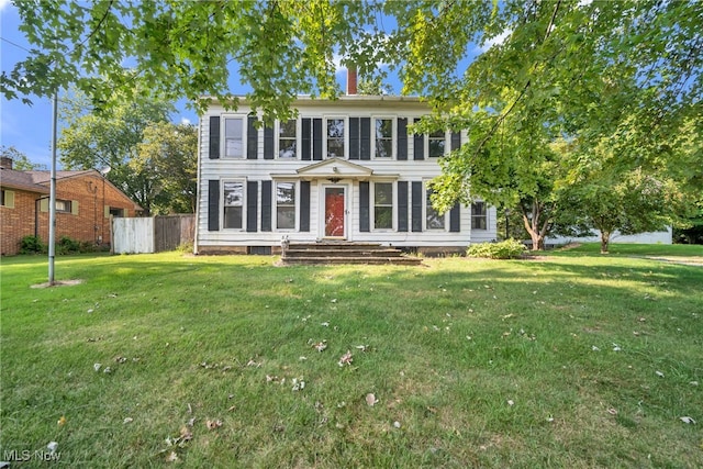 colonial-style house featuring a front lawn