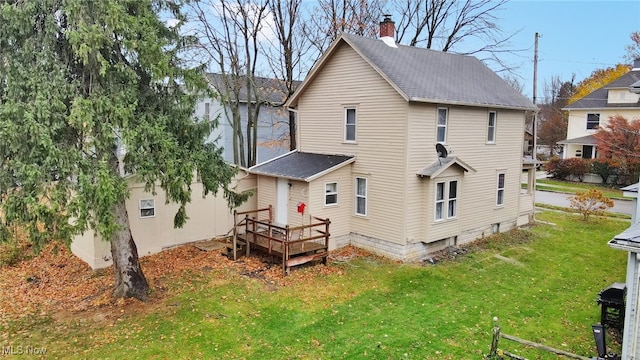 back of house featuring a lawn