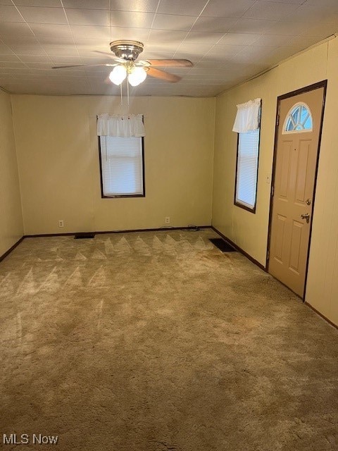 carpeted spare room featuring ceiling fan