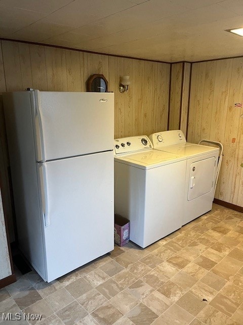 laundry area featuring washer and clothes dryer and wood walls