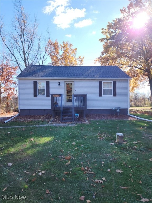 view of front facade with a deck and a front yard