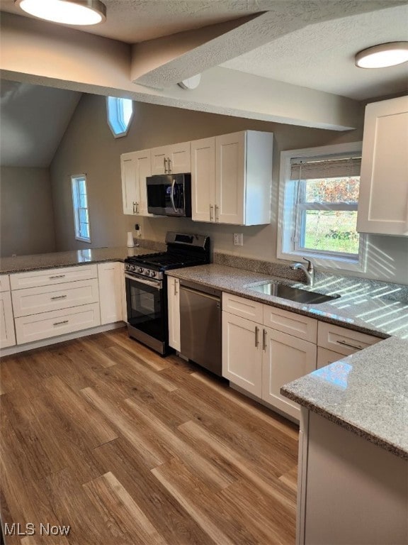 kitchen with light hardwood / wood-style floors, white cabinetry, sink, and appliances with stainless steel finishes