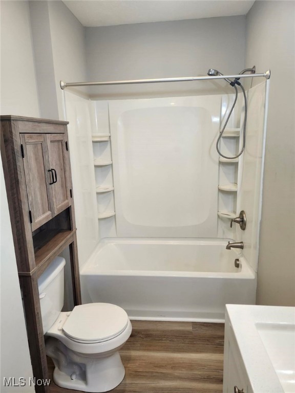 full bathroom with shower / tub combination, hardwood / wood-style floors, vanity, and toilet