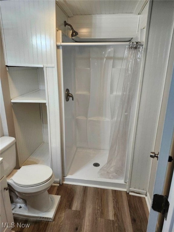 bathroom featuring hardwood / wood-style floors, a shower with curtain, toilet, and vanity