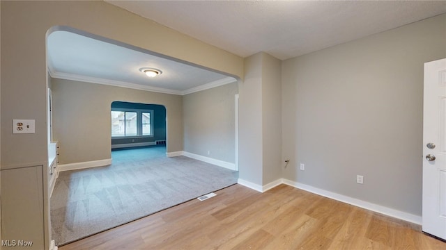 spare room with crown molding and light hardwood / wood-style flooring