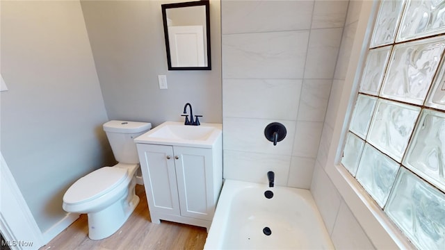 bathroom featuring wood-type flooring, vanity, toilet, and a bathing tub