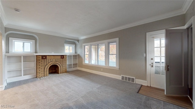 unfurnished living room with crown molding, light colored carpet, and a brick fireplace