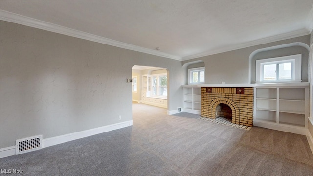 unfurnished living room featuring carpet flooring, a fireplace, a wealth of natural light, and crown molding