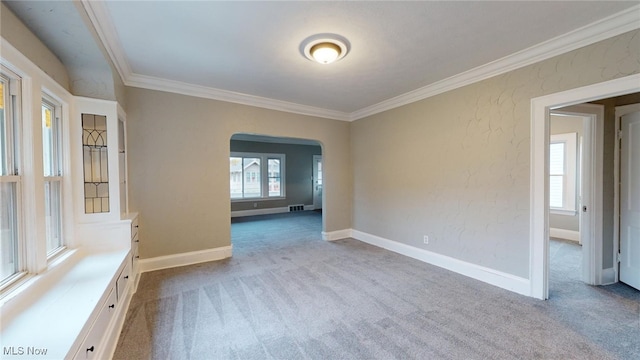 carpeted empty room featuring crown molding