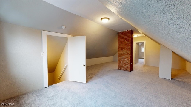 additional living space featuring light carpet, a textured ceiling, and lofted ceiling