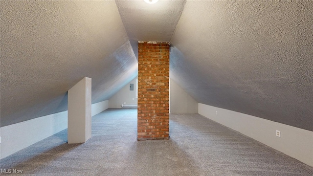 additional living space featuring vaulted ceiling, carpet floors, and a textured ceiling