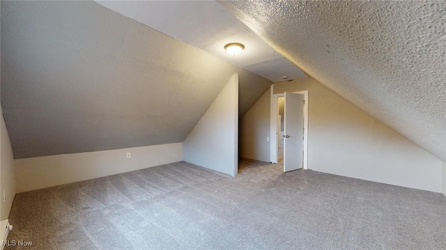 bonus room featuring a textured ceiling, light carpet, and vaulted ceiling