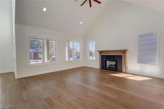 unfurnished living room featuring ceiling fan, light hardwood / wood-style flooring, and high vaulted ceiling