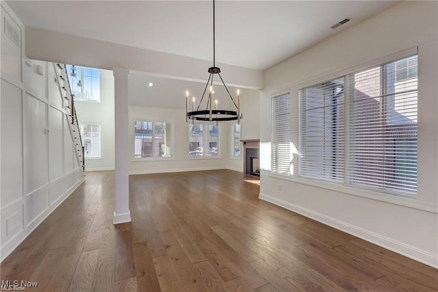 unfurnished living room with dark wood-type flooring and a notable chandelier