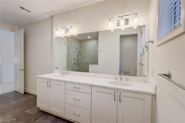 bathroom featuring vanity, wood-type flooring, and walk in shower