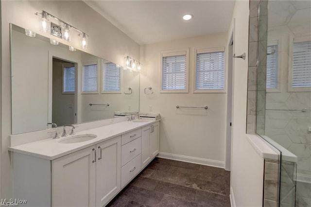 bathroom with a tile shower and vanity