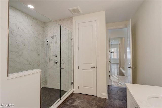 bathroom featuring vanity and a shower with door