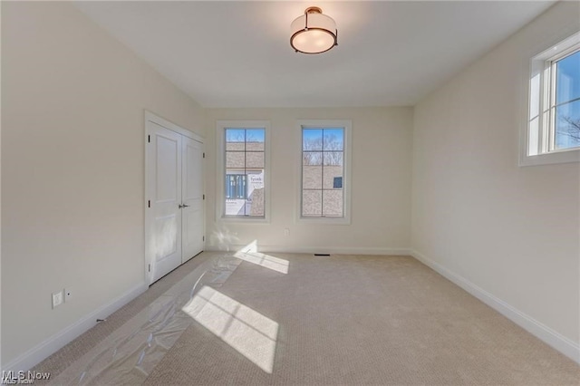 spare room featuring light colored carpet