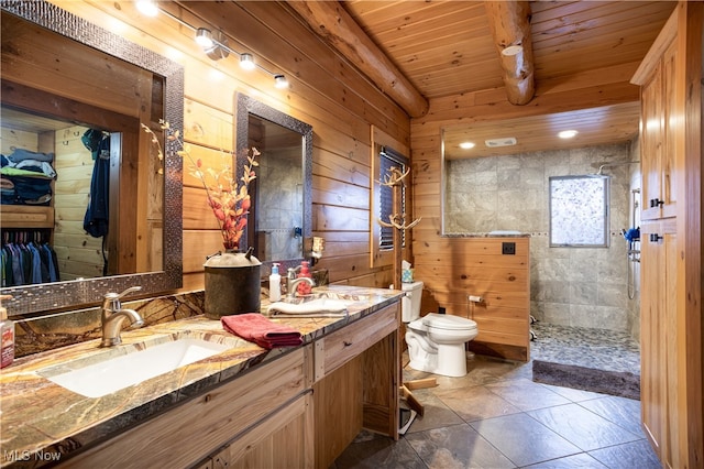 bathroom with a tile shower, tile patterned floors, wooden walls, vanity, and wood ceiling