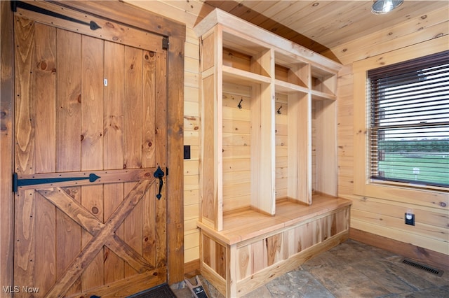 mudroom featuring wood ceiling and wood walls