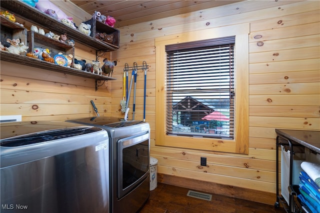 laundry room featuring wooden ceiling, separate washer and dryer, dark wood-type flooring, and wood walls