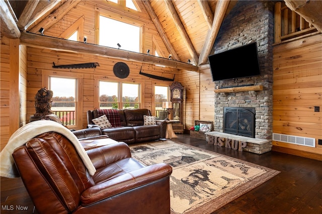 living room with a stone fireplace, wood walls, dark wood-type flooring, and wooden ceiling