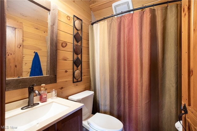 bathroom with vanity, toilet, and wooden walls