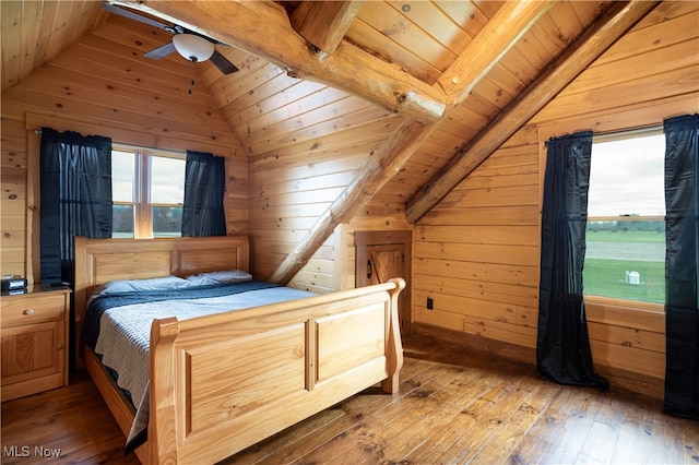 bedroom with lofted ceiling and wooden walls