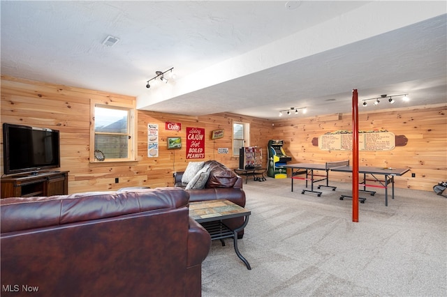 living room with carpet flooring, wooden walls, and track lighting