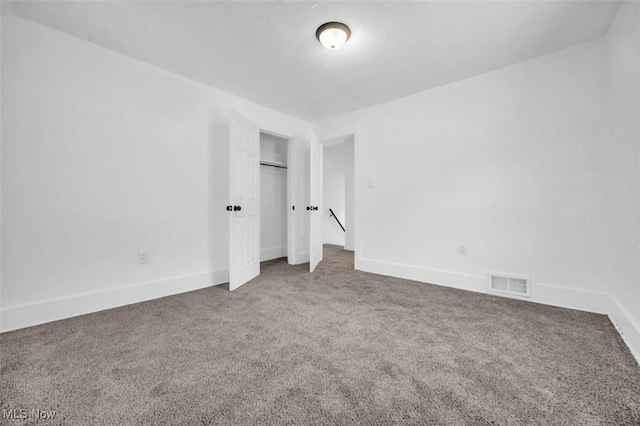 unfurnished bedroom featuring a closet, baseboards, visible vents, and carpet flooring