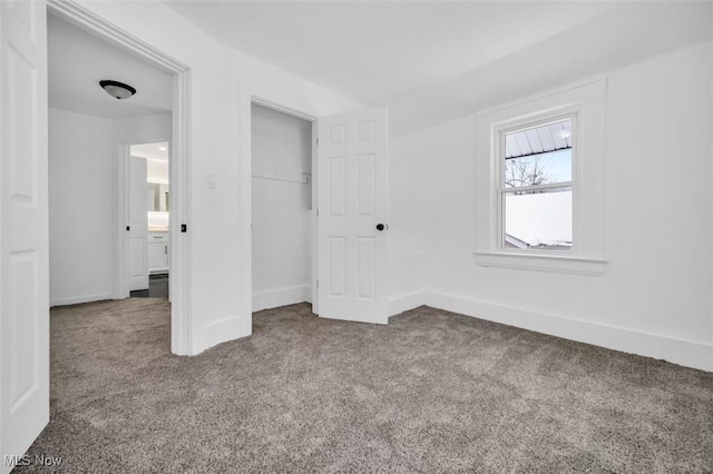 unfurnished bedroom with carpet floors, a closet, and baseboards