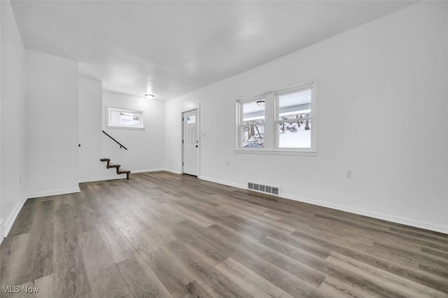 interior space featuring stairway, baseboards, visible vents, and wood finished floors