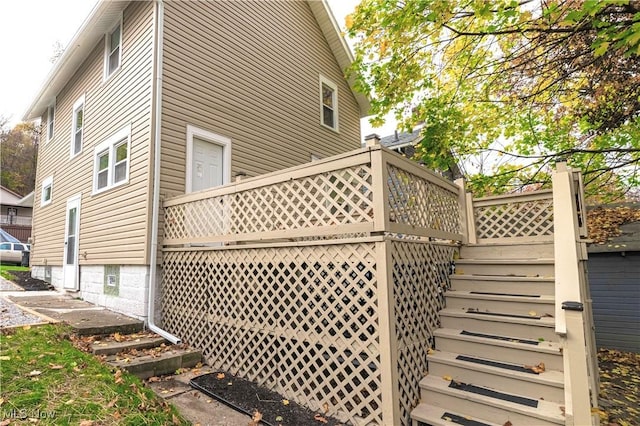 view of property exterior featuring a deck and stairway