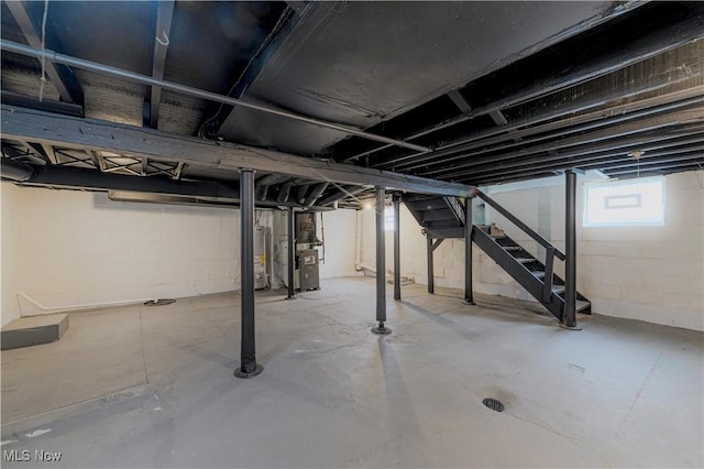 basement with water heater, stairway, and heating unit